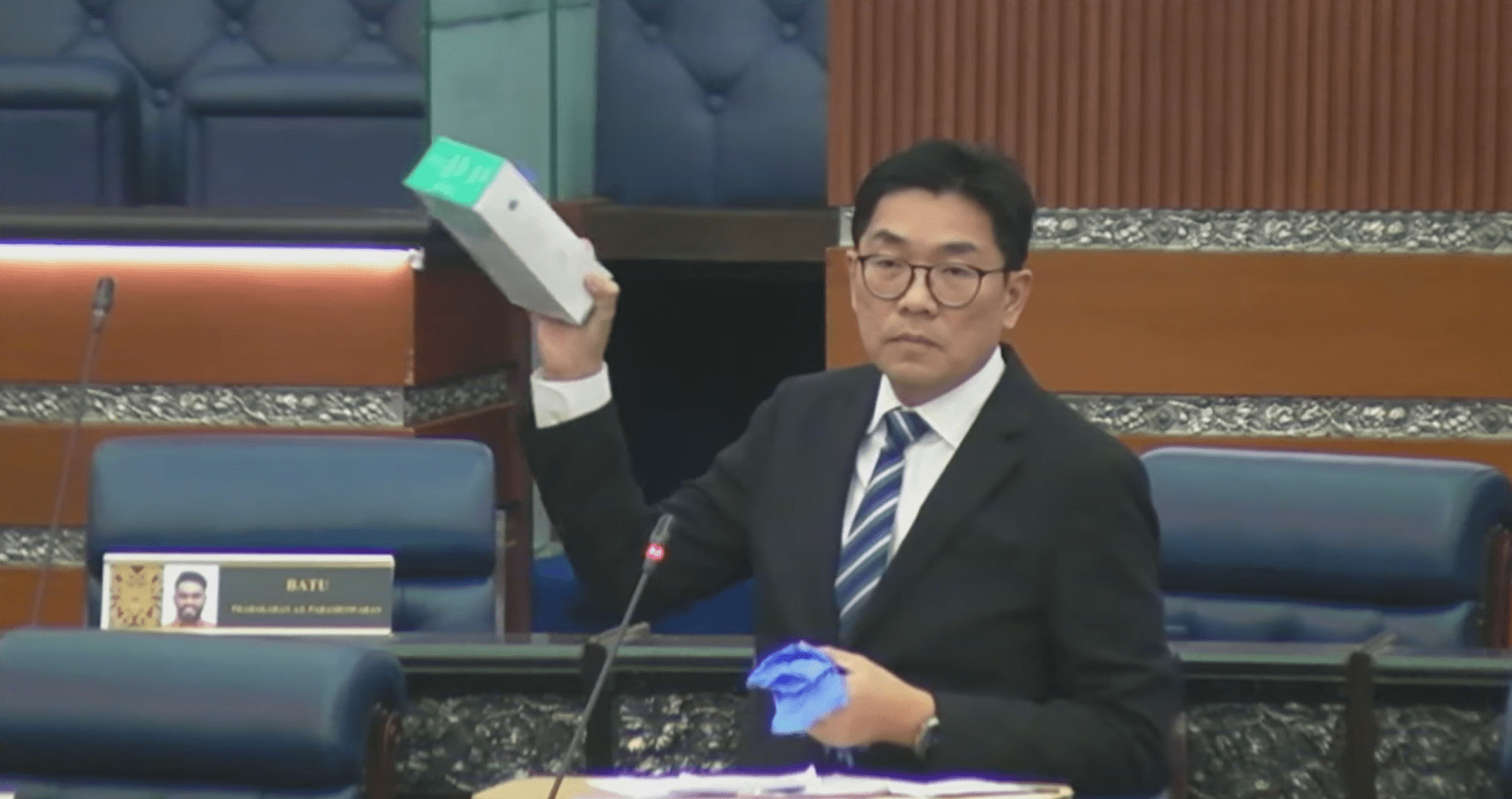 Sim Tze Tzin showing a box of gloves