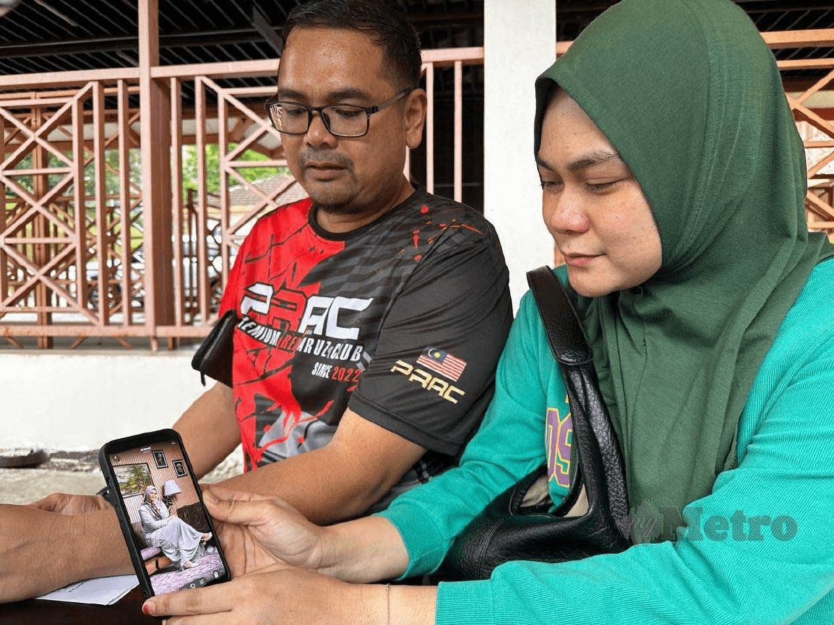 Siti's family looks at her photo