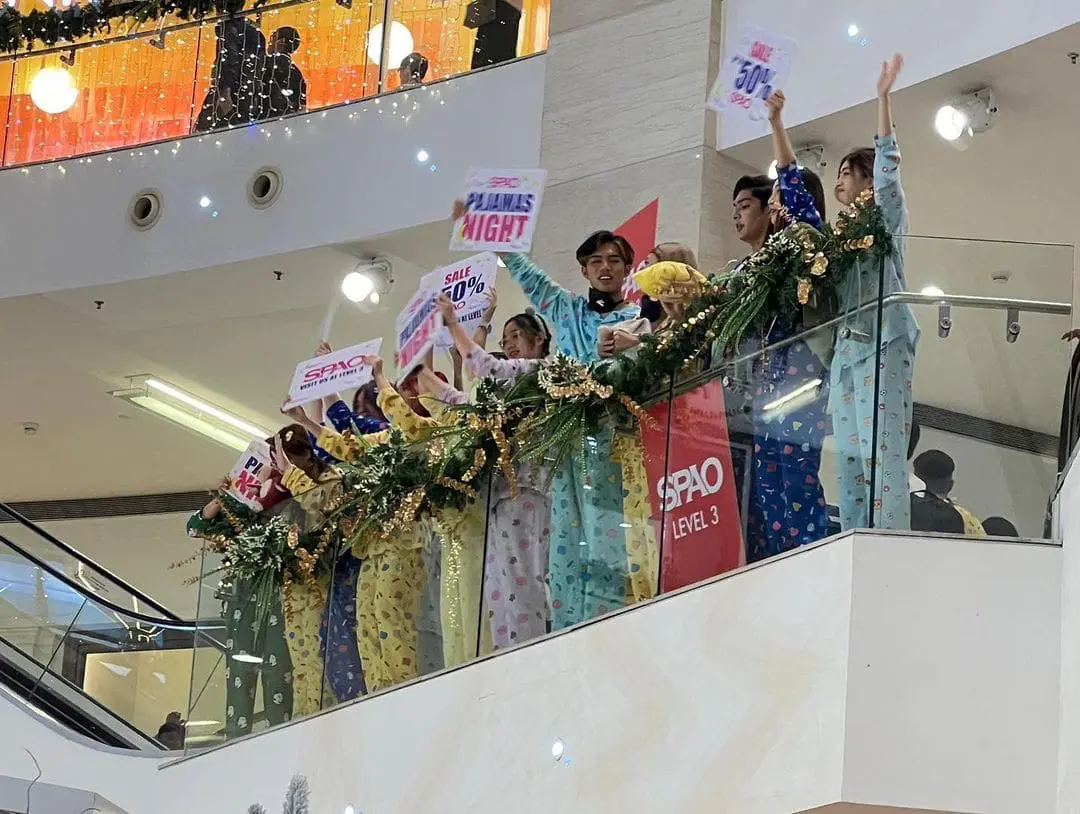 Msian Influencer at Pavilion KL waving the SPAO discount card to the crowd in the mall.