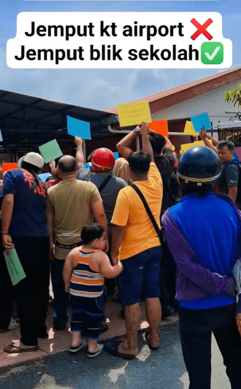 Some parents tiptoeing while waiting in front of school