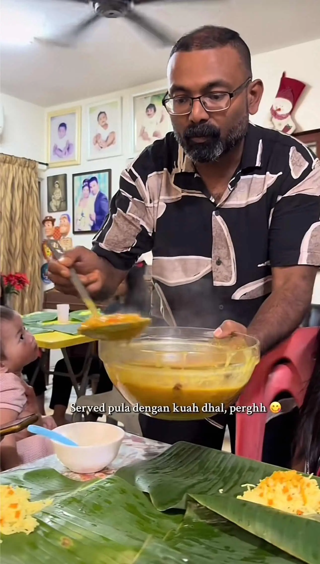 Stan pouring dhal on the rice for Hanis and their family