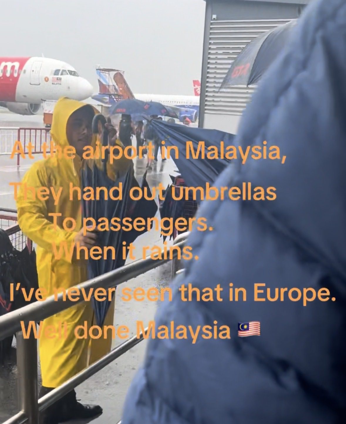 “This Would Never Happen In Europe” — Tourist Amazed As M’sian Airport Staff Give Out Umbrellas During Rainstorm