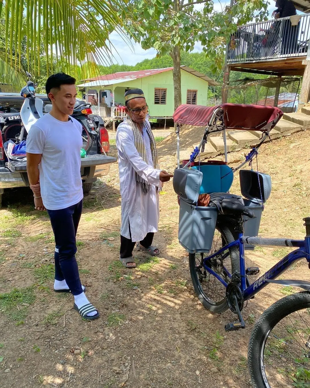 uncle basri showing his bicycle to adrian