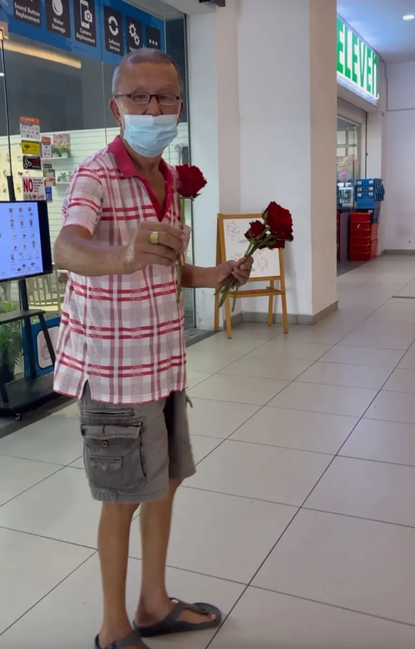 uncle givng out roses to starngers