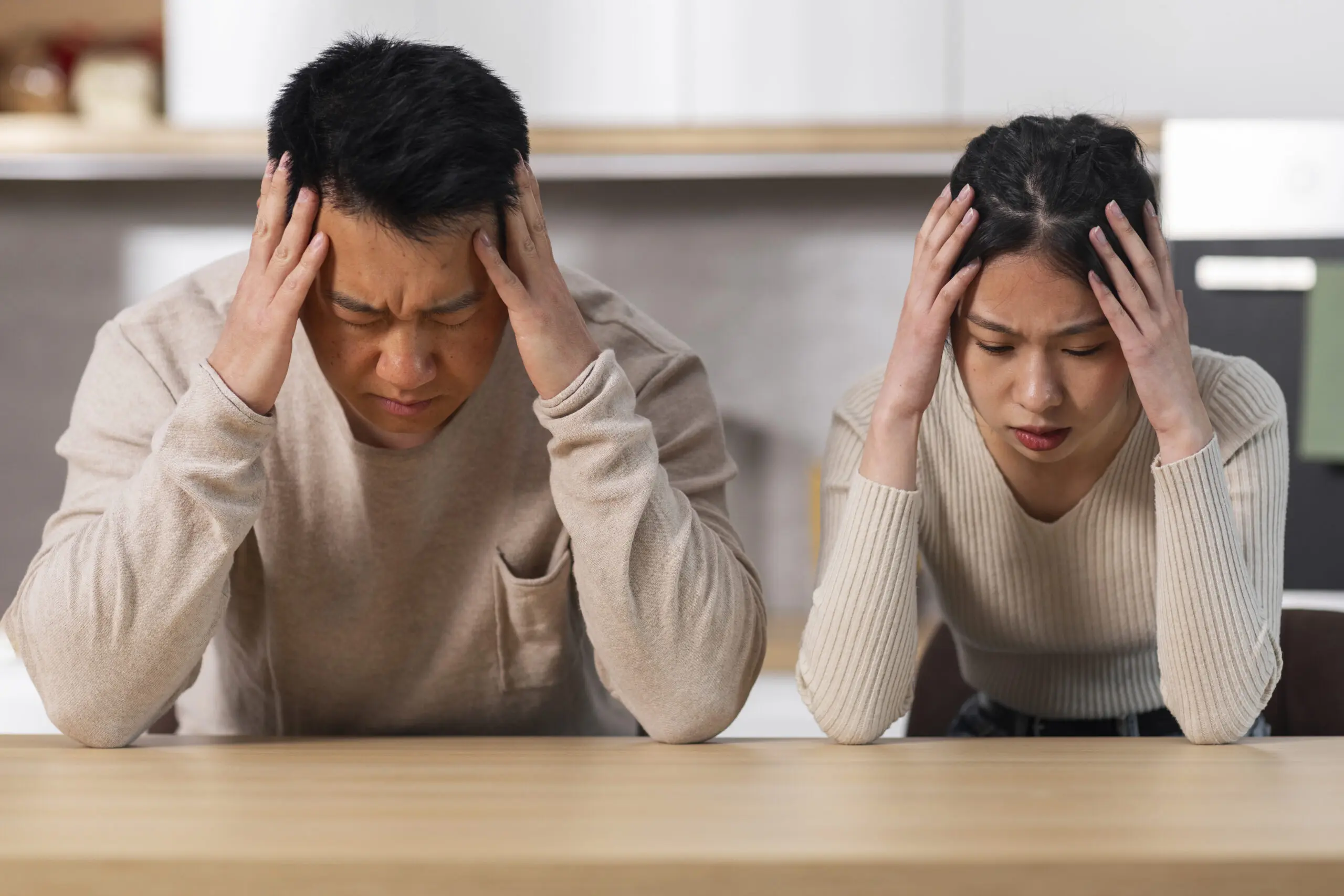 Stressed couple sitting at their home
