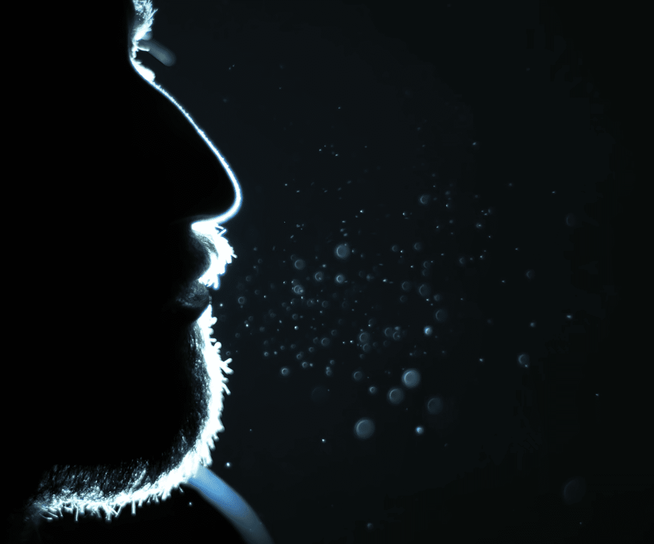 Water droplets emerging from man's mouth