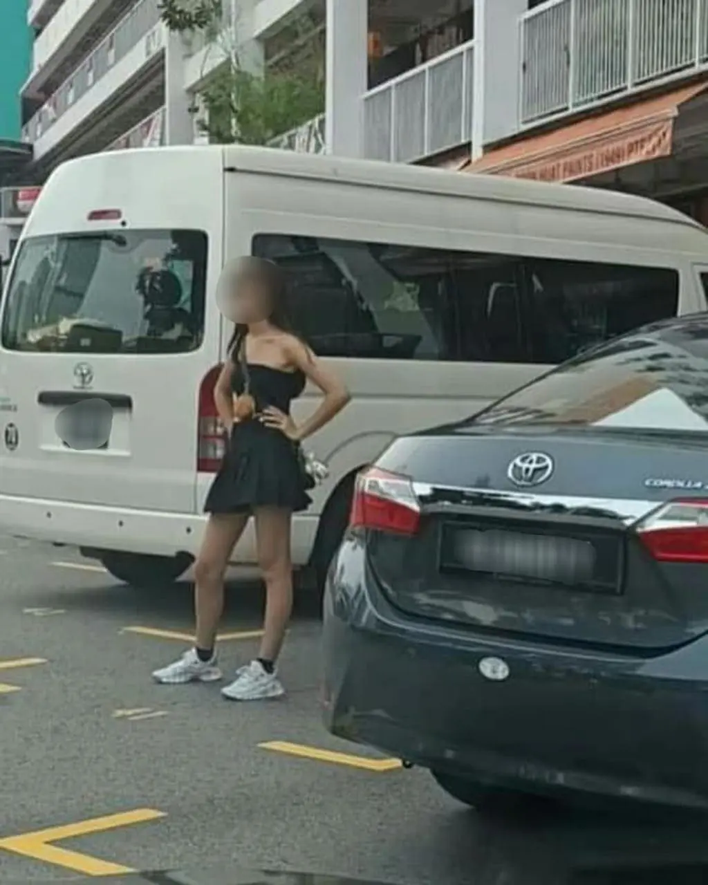 msian woman standing at an empty parking spot reserving for her friend