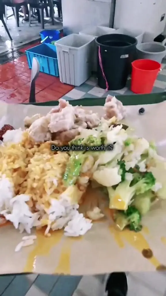 man showing a plate of mix rice that he bought for this lunch