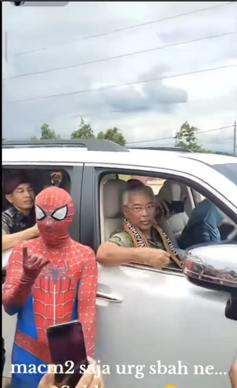 Msian dressed as spiderman taking photo with Agong