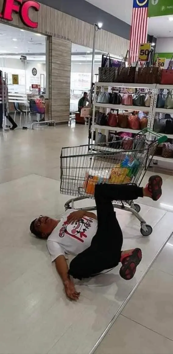 a msian man fell on the ground in a shopping mall