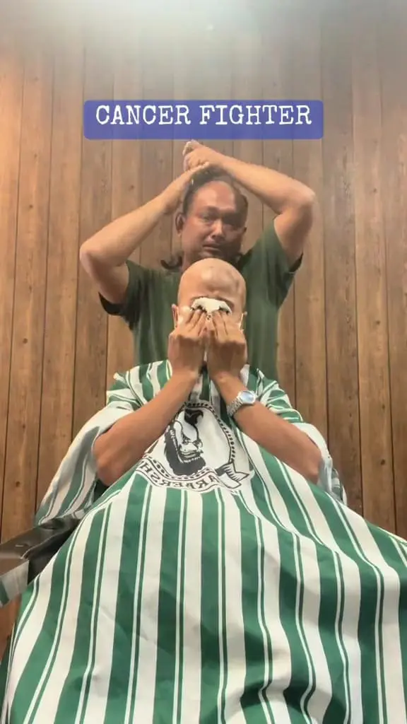 Msian man shaving his head after shaving his wife's head who is suffering from cancer