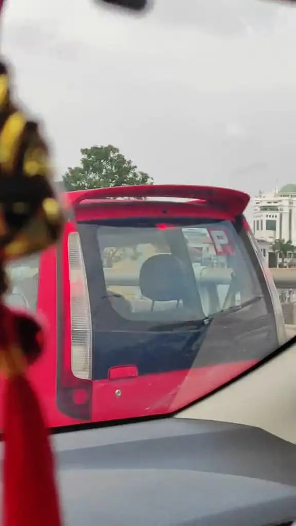 The female even sticks a P-Sticker behind her car.