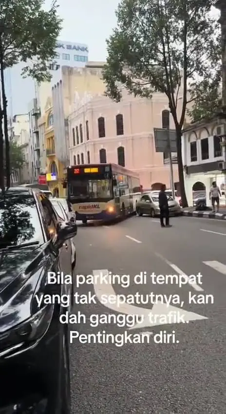 The RapidKl bus is honking directing teh car owner to move their cars
