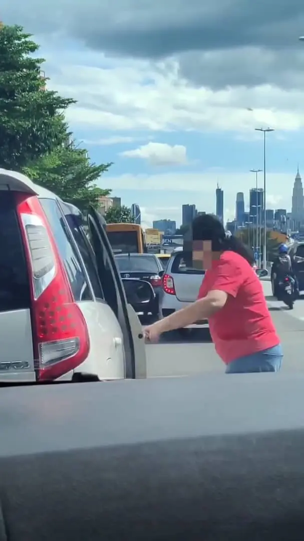 Msian woman forcefully opening the other car's door. 