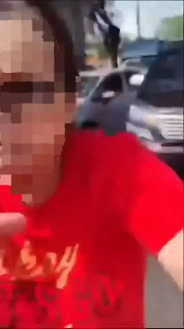 A msian woman stopping the person from recording her. 