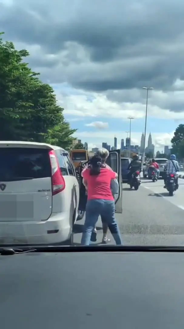 Msian woman pushing another driver from behind. 