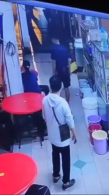 A customer follows the food vendor from behind. 