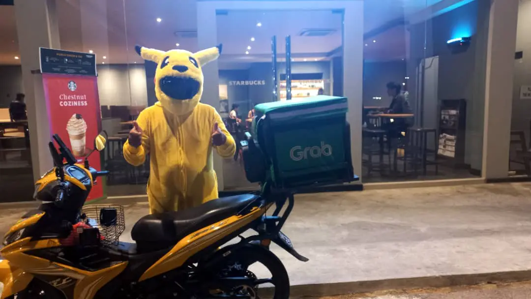 M'sian Grab Food Rider, who is in Pikachu cuite, is standing in front of a Starbucks store at Port Dickson.