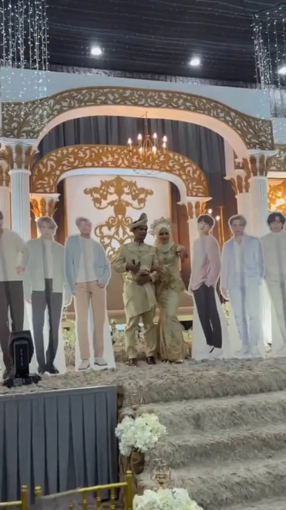 M'sian couple taking photo with BTS standees at their wedding reception.