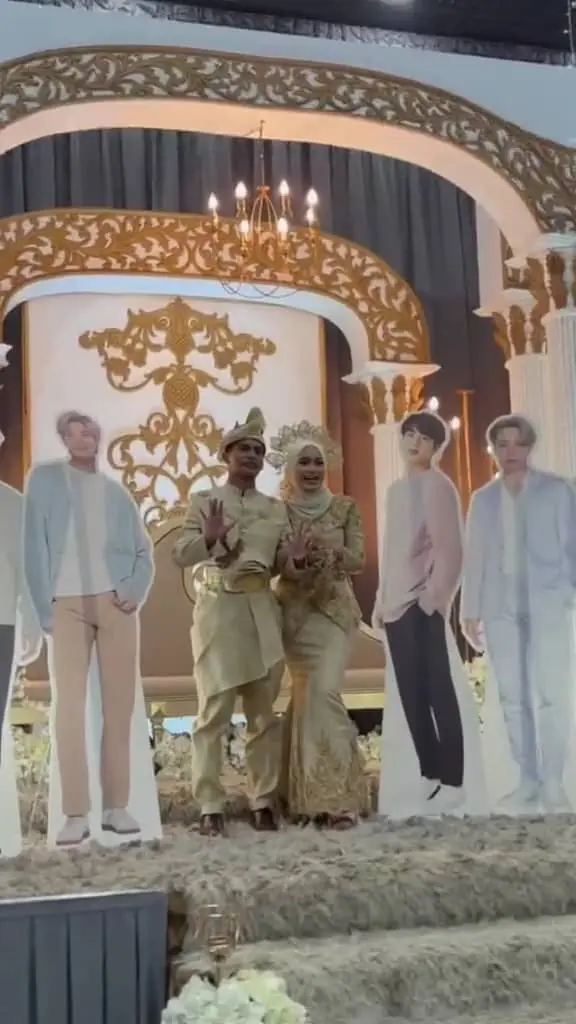 M'sian couple taking photo with BTS standees at their wedding reception.