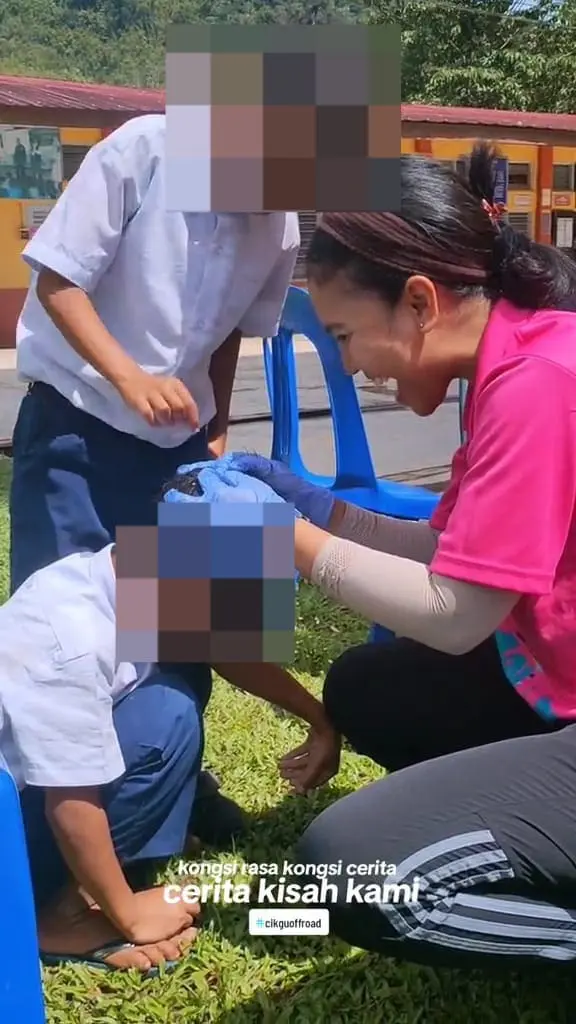 Msian teacher looking through the kids hair for lice 