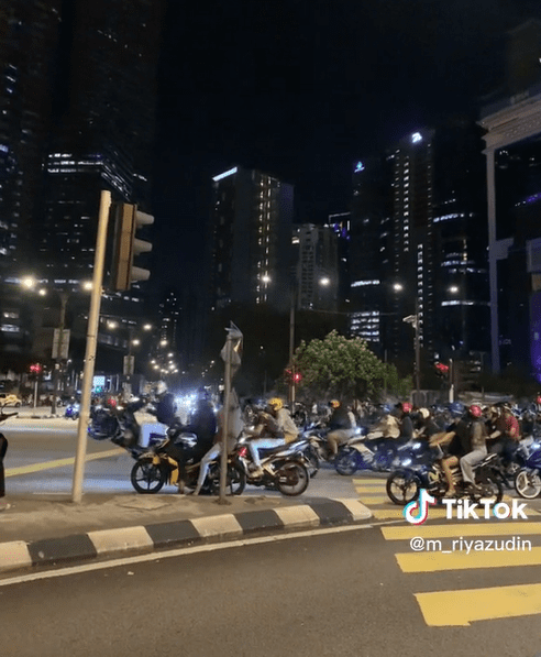 'Mat Rempit' does a wheelie at a traffic light near KLCC