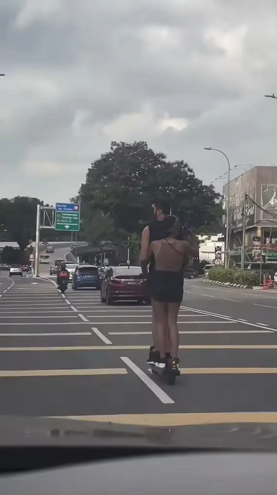 Woman films scenery while on scooter in KL