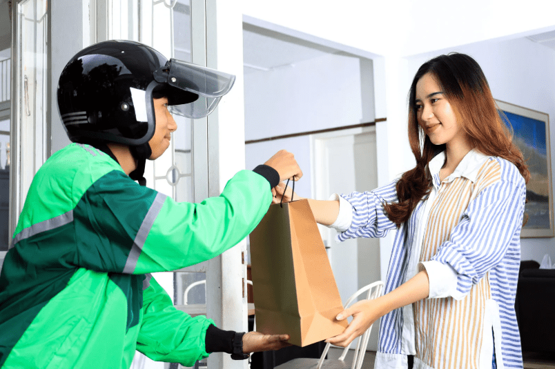 Woman getting order from delivery rider