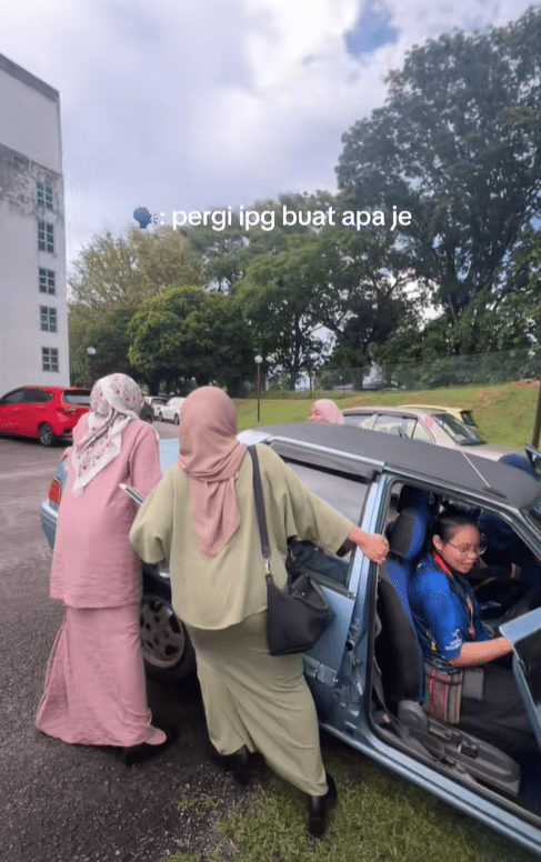 Woman in baju kurung pulling car out of drain