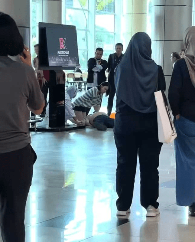 Woman performing CPR on Law at Kuching airport