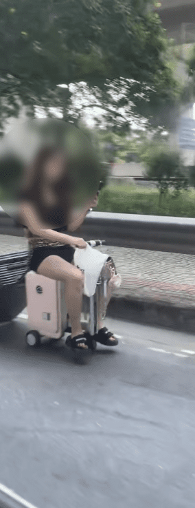 woman riding motorised luggage