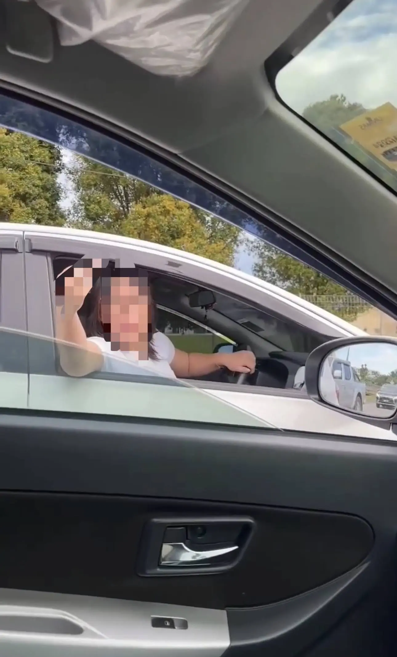 Woman shows middle finger to another driver