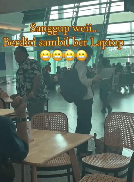 womna doing work while standing at penang international airport