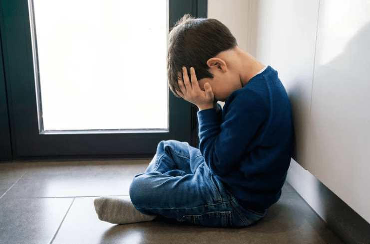 Young boy covering his face