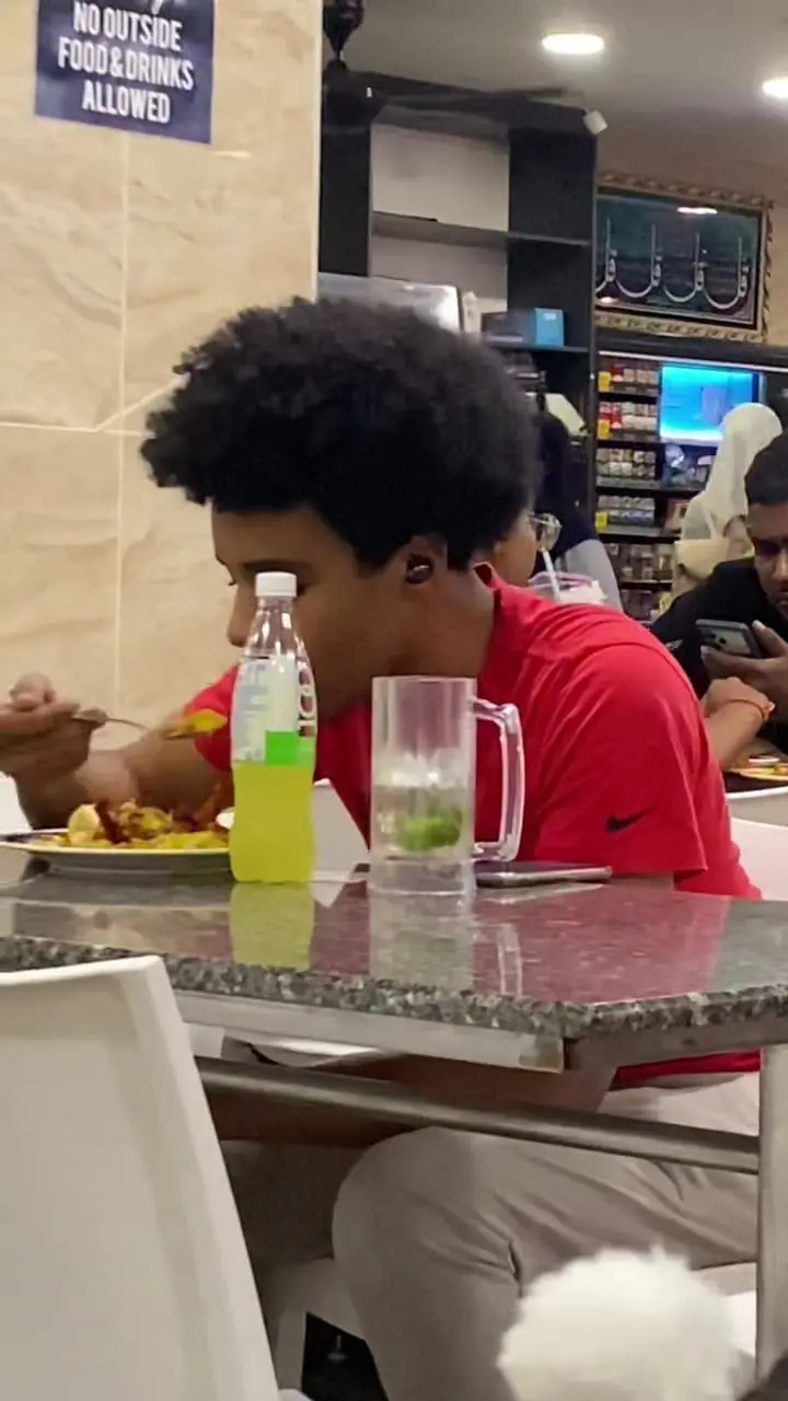 young man eating at mamak restaurant