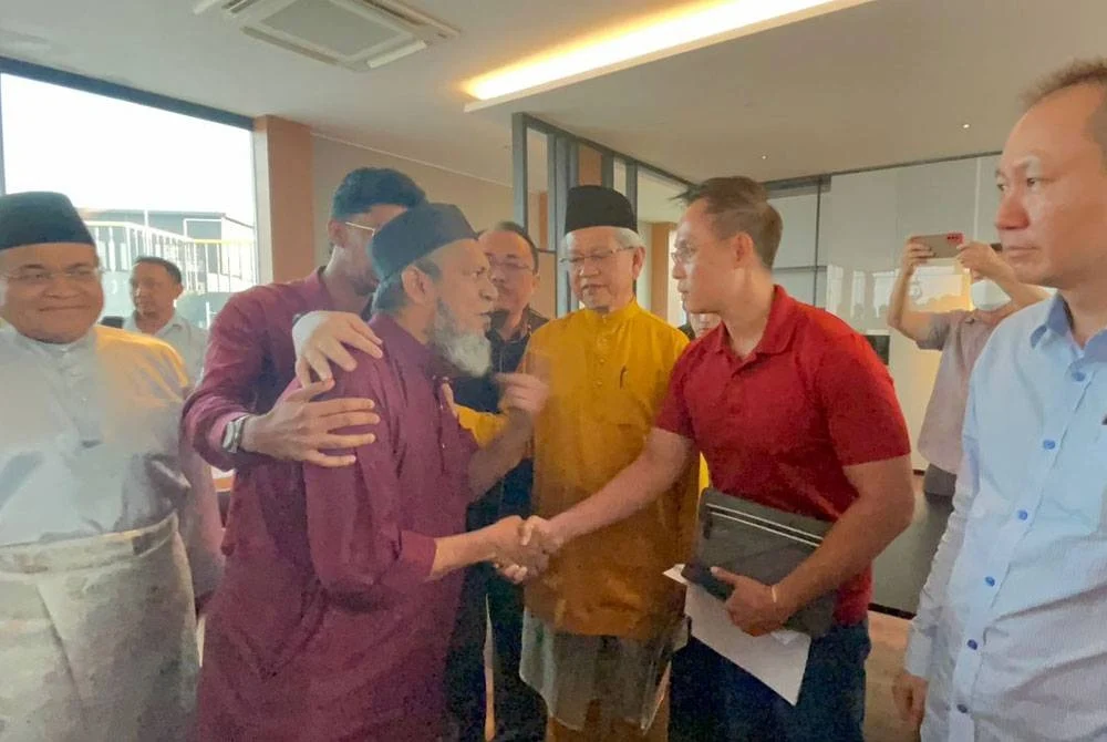 Try Pinnacle manager Alex Low shaking hand with Surau Saidina Umar manager, Muhammad Nasir.