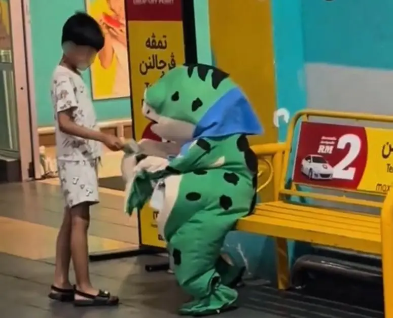 "Too Young for This" - Boy In Frog Costume Seen Collecting Donations Alone Under The Hot Sun In Parking Lot