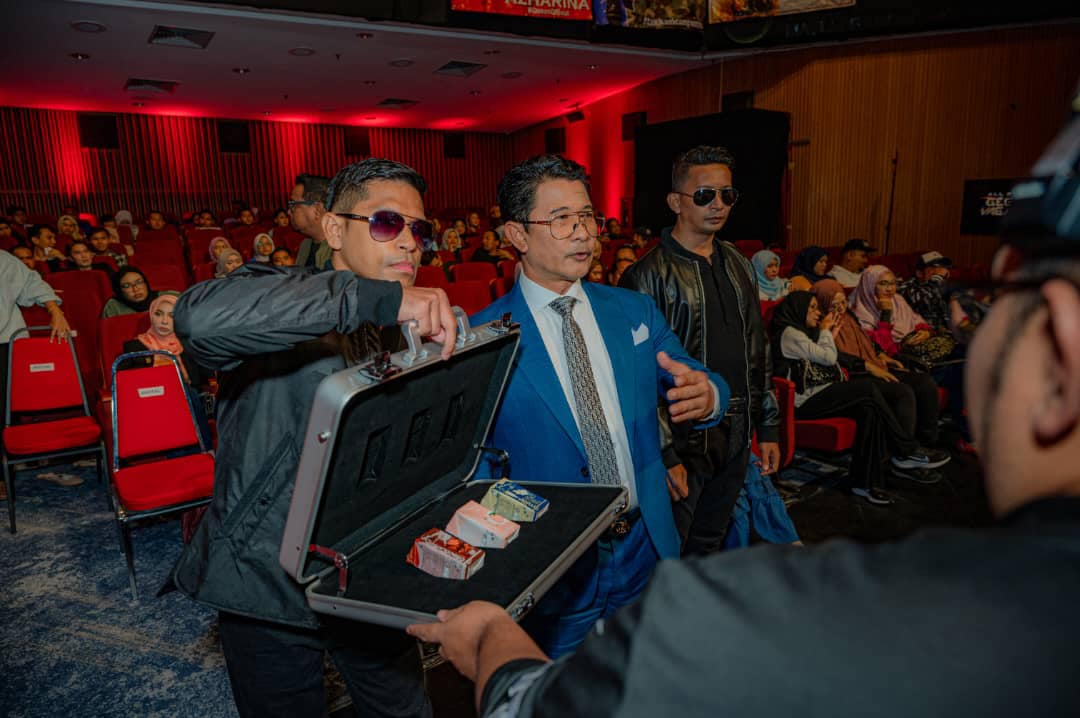 Azmi Zainal's representative opened a suitcase with his products to another person at a show.