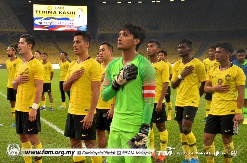 Malaysian footballers shows respect to Negaraku anthem but putting their right hands on their chests.