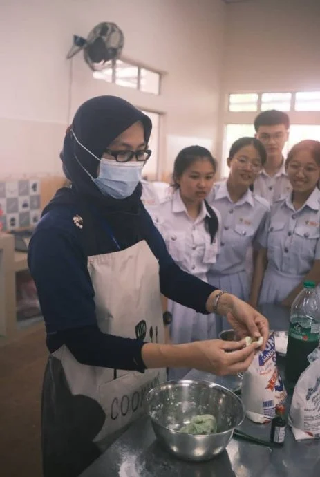 Cikgu Suzana teaching students how to make Malay kuih