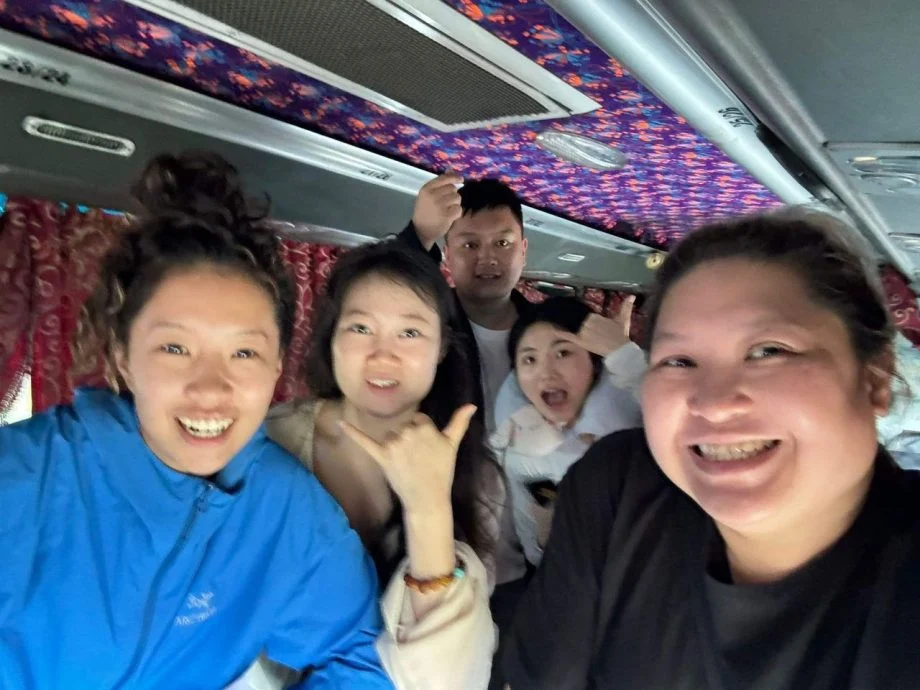 Shen Guanru with tourist in a bus