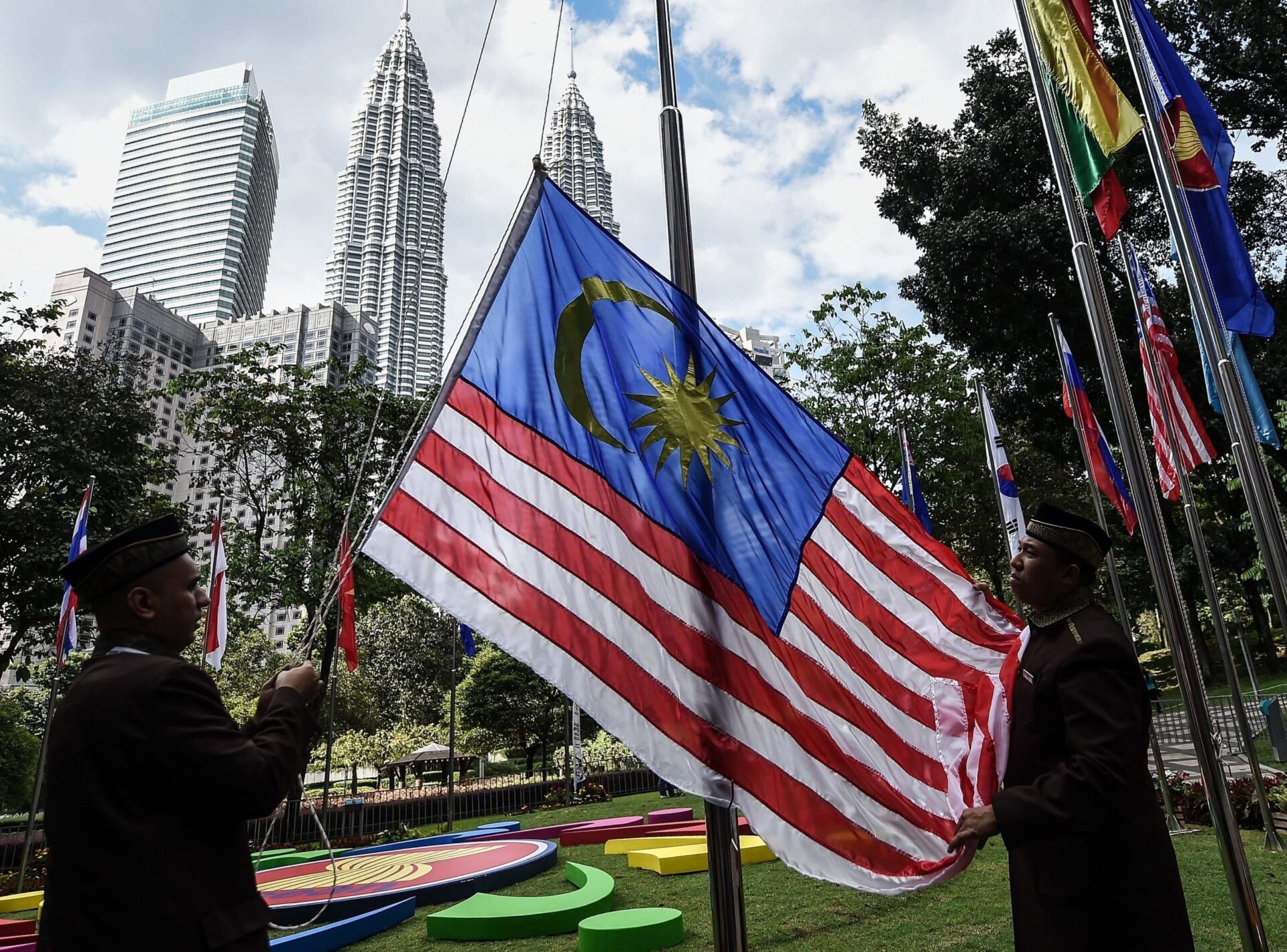 Officers hoisting the Jalur Gemilang