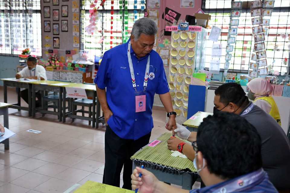 Ahmad Said wearing attire that has political symbol during voting day at polling station