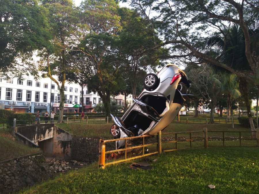 Car landing in upright position on divider in Johor