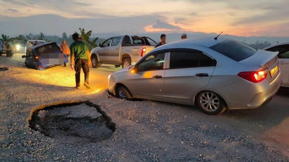 cars trapped in huge potholes in kedah road