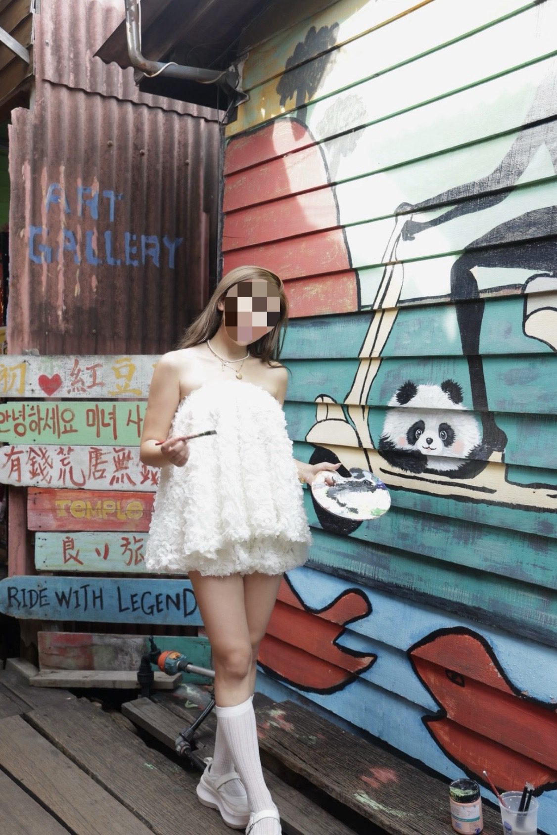 China tourist poses with panda mural