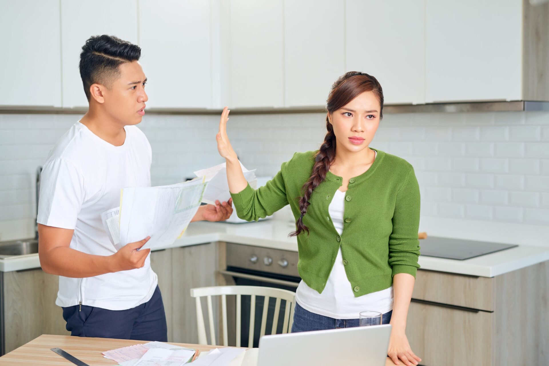 Upset young couple with financial bills having conflict at home