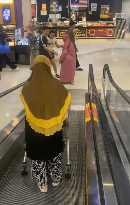 Couple helps makcik on escalator (2)