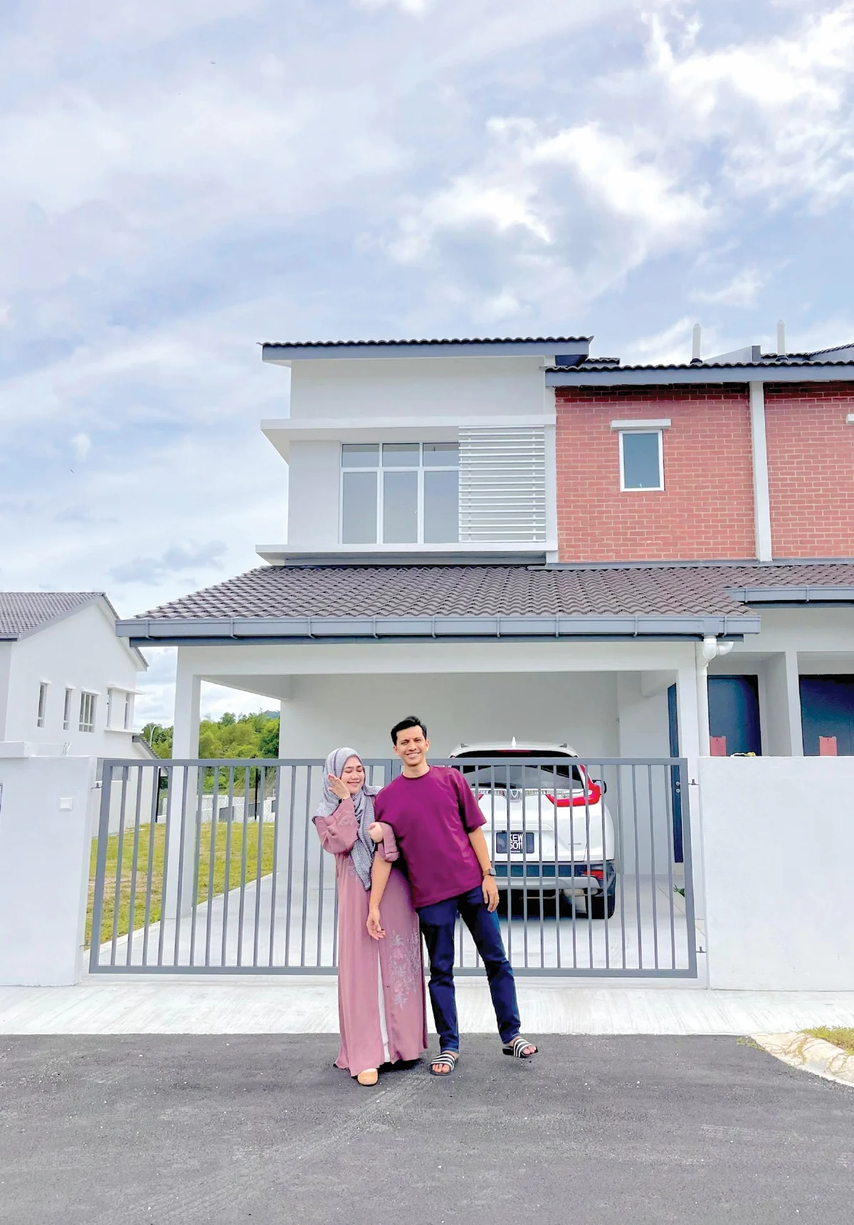 couple standing infront of their newly bought house