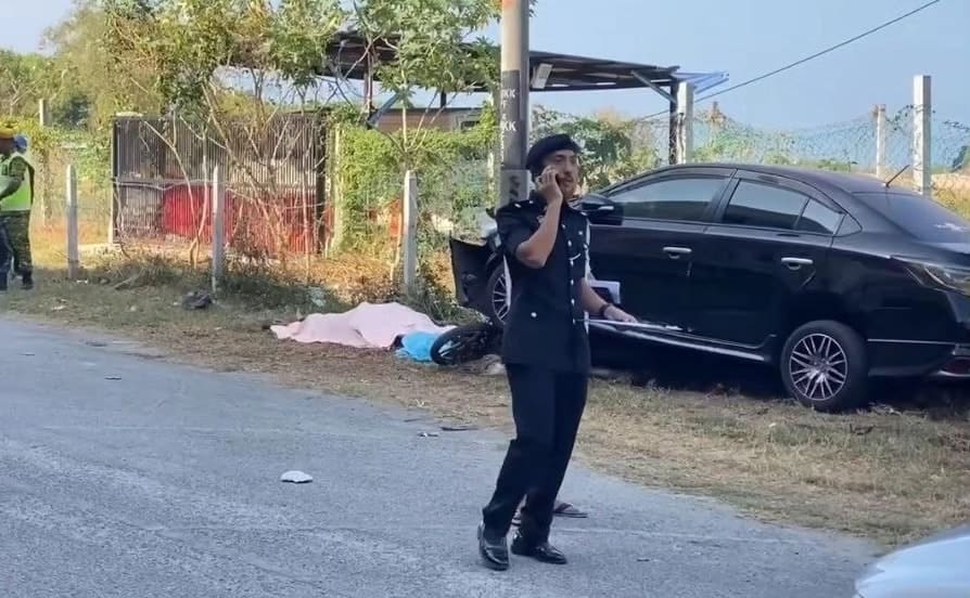 M'sian policeman walks by the body of dead thief in Kedah